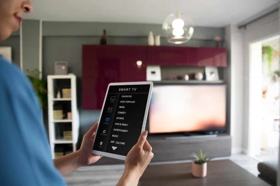 a black woman holding a tablet with Smart TV control functions