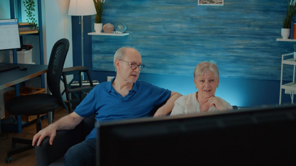 An elderly couple watching TV