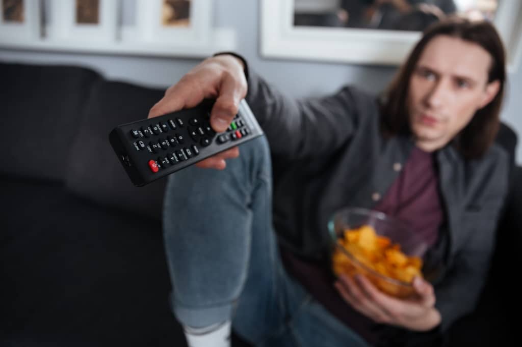 Man switches channels with remote control