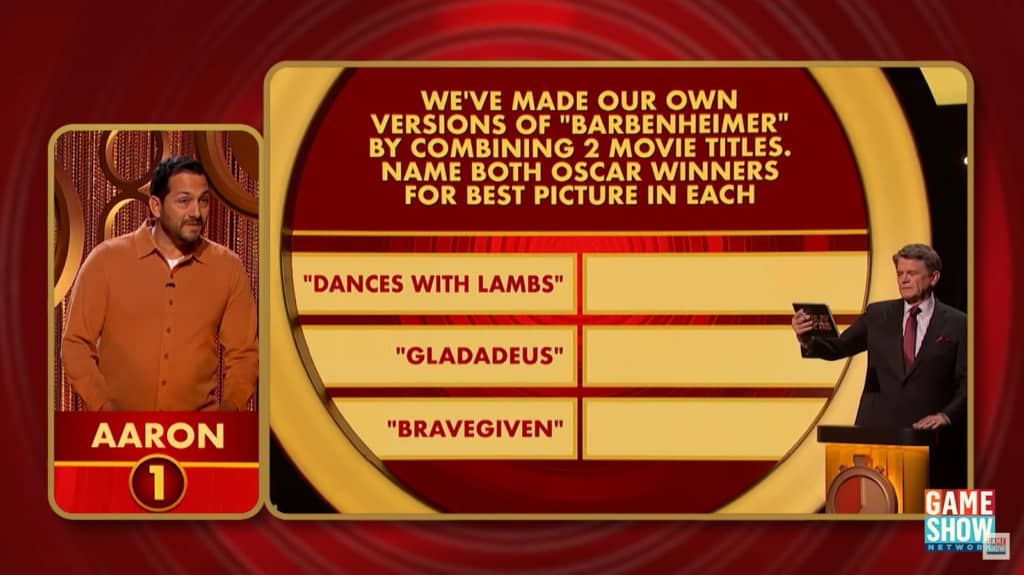 The game show host presents a question about combined movie titles