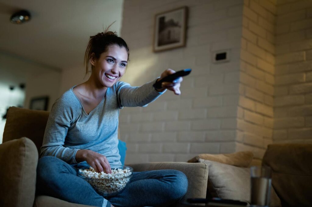 Woman having fun changing channels on TV